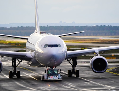 white and blue airplane on airport during daytime