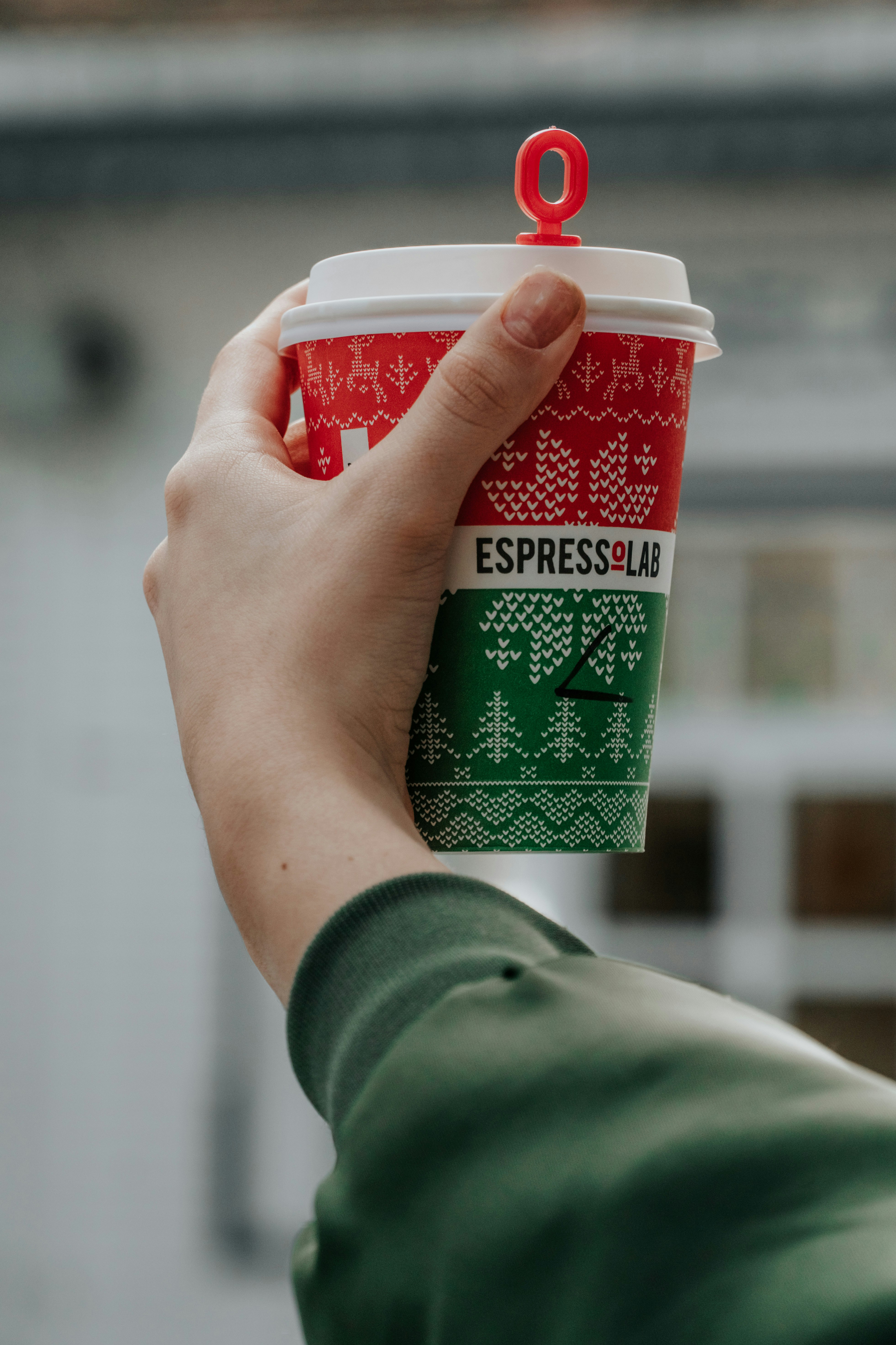 person holding green and white plastic cup