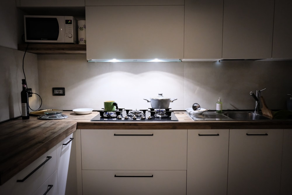 white wooden kitchen cabinet with stainless steel sink