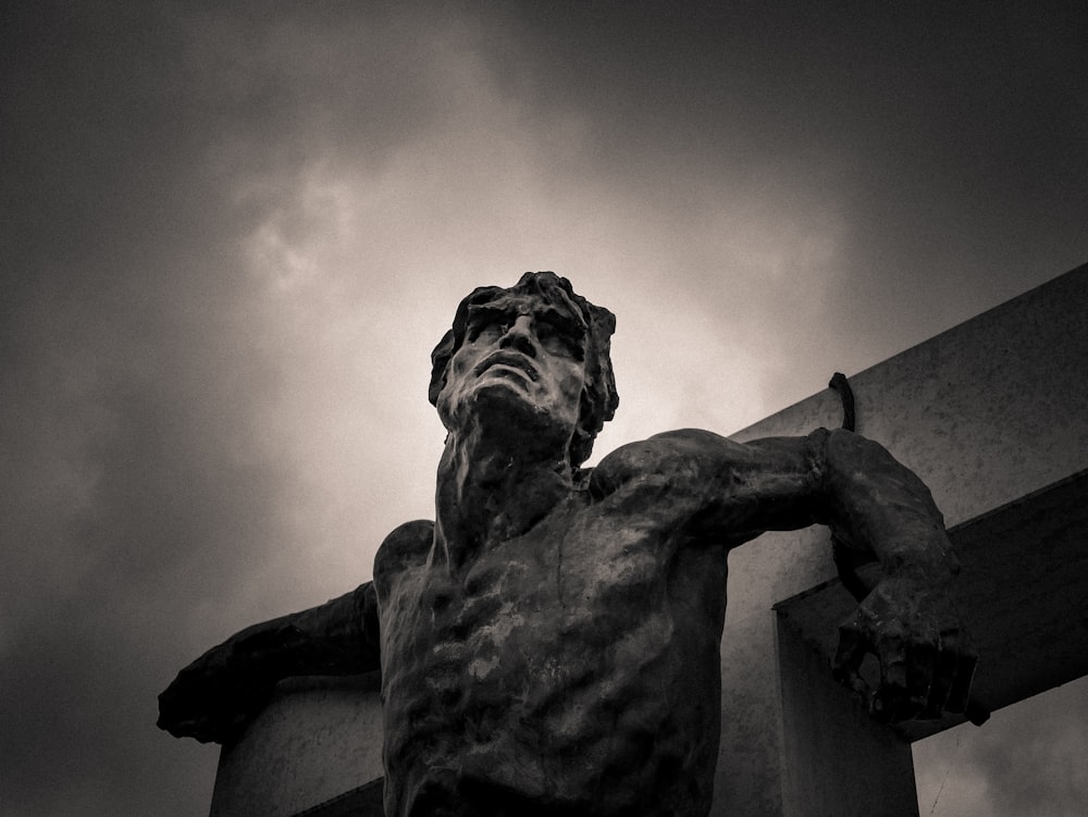 Foto en escala de grises de la estatua del hombre