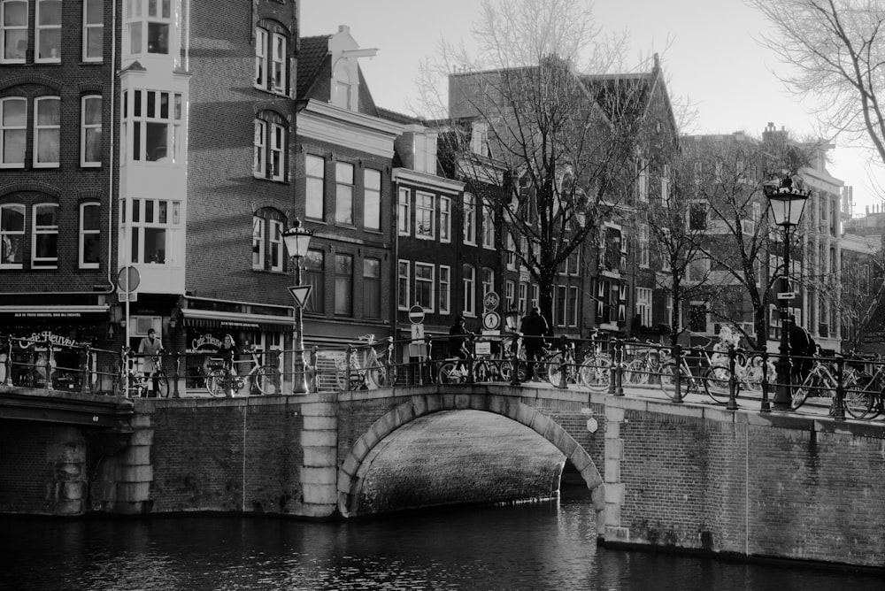 grayscale photo of concrete bridge over river