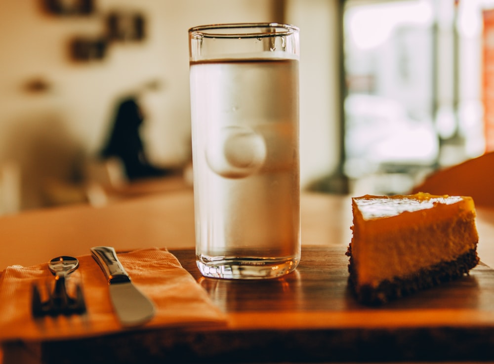 clear drinking glass with milk on brown wooden table