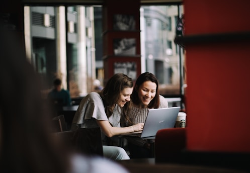 Two women sharing ideas over coffee in a cozy, sunlit space.