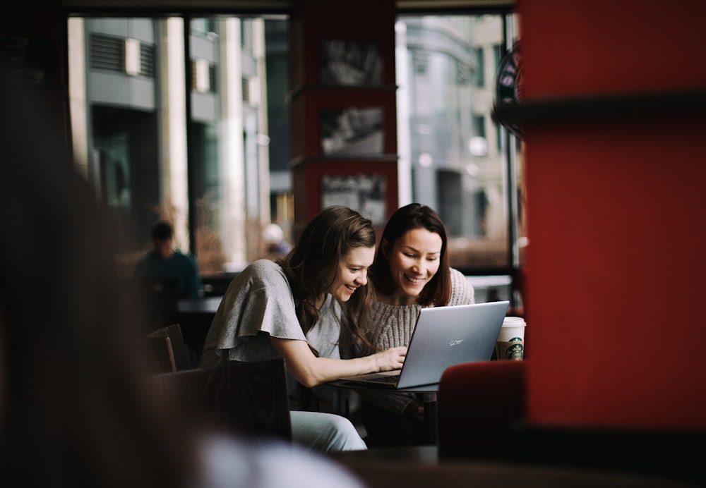 MacBookを使用する白いシャツの女性