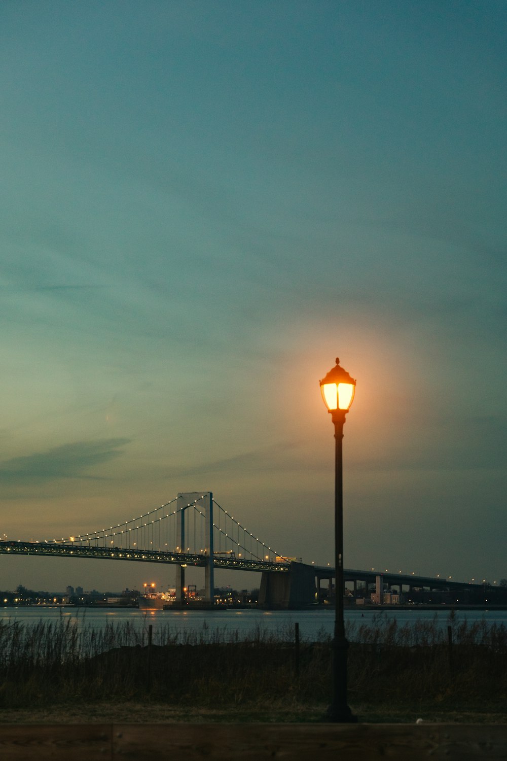 beleuchtete Pfostenlampe in der Nähe der Brücke während der Nachtzeit