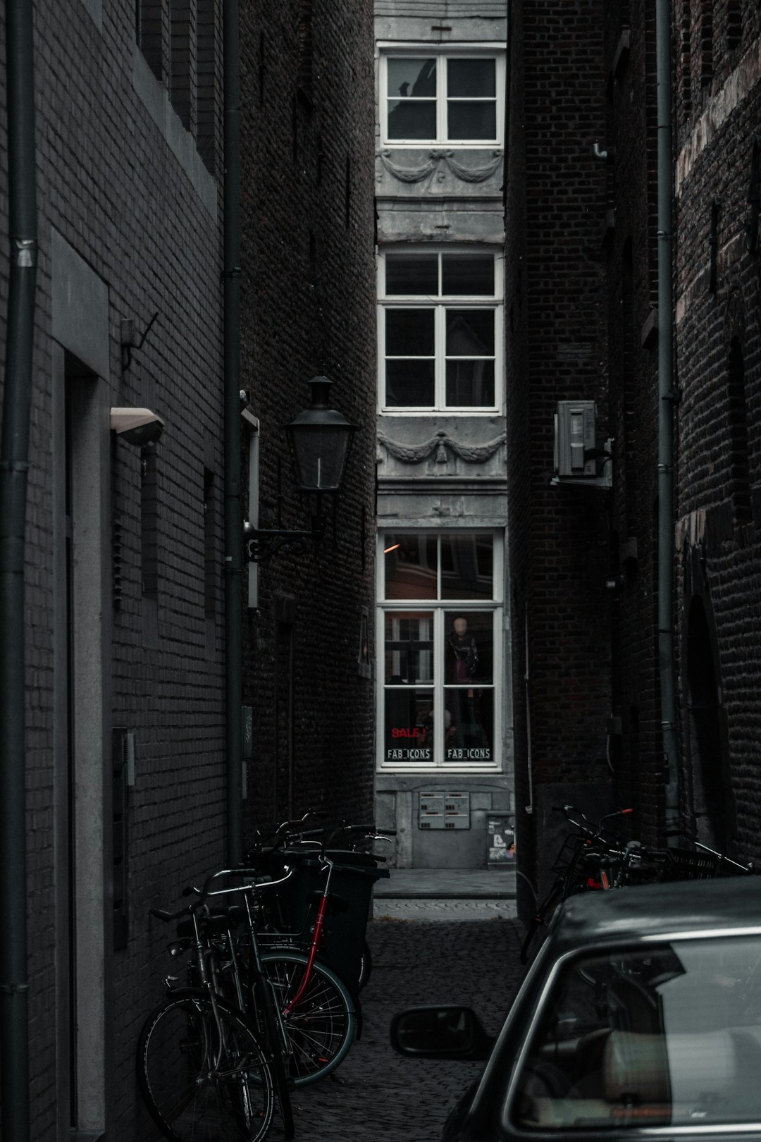 black bicycle parked beside brown brick building