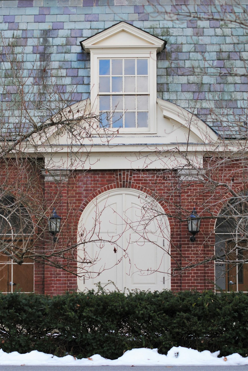 Edificio de ladrillo marrón con ventana de madera blanca