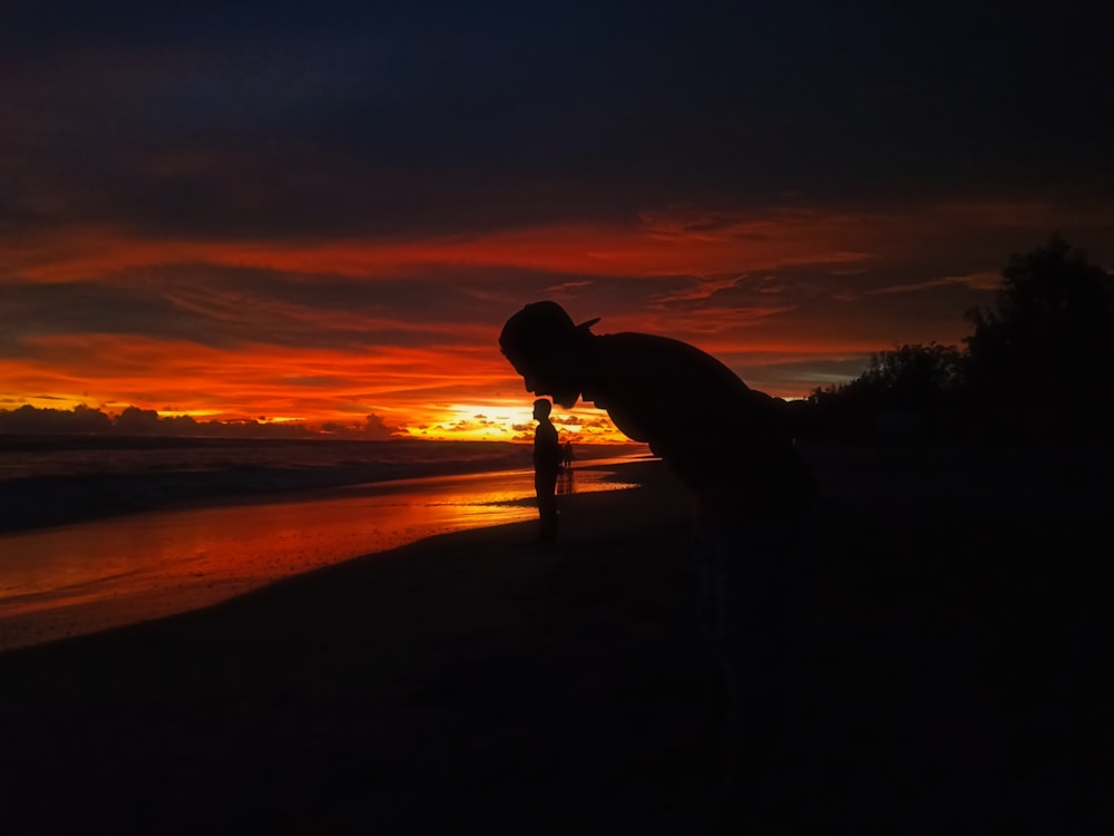 silhouette of man and woman kissing during sunset