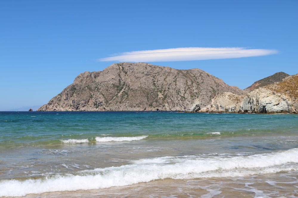 Montaña marrón y verde junto al mar durante el día