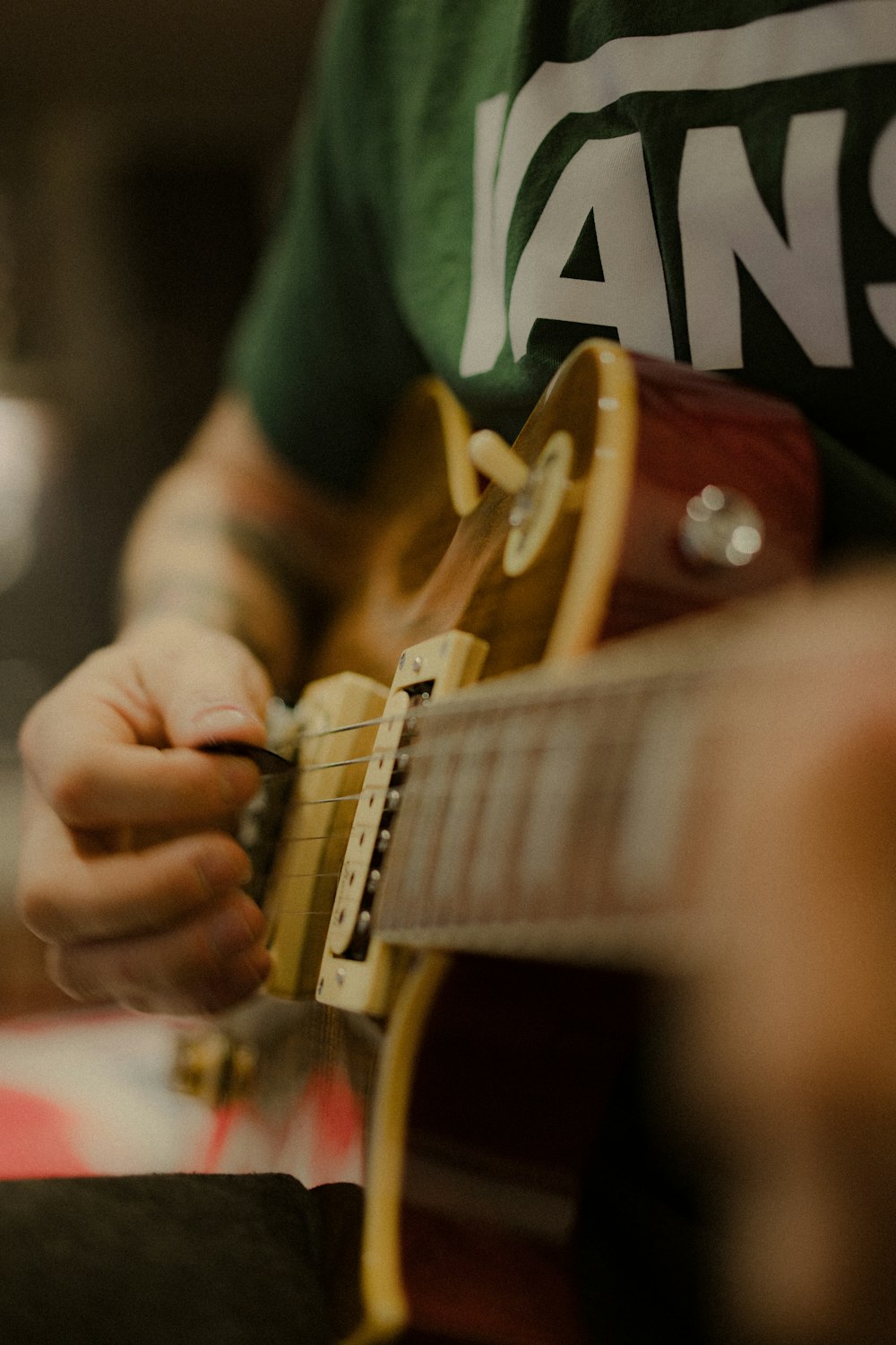 person playing brown and white electric guitar