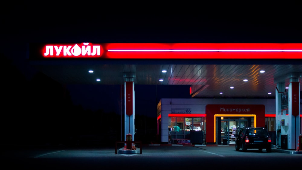 um posto de gasolina iluminado à noite com luzes de néon