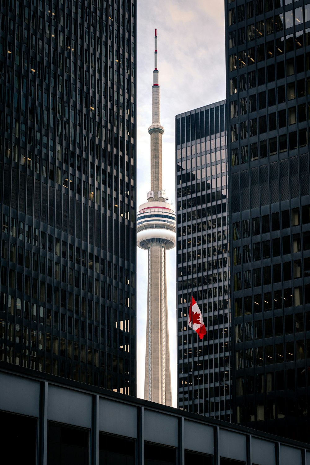 Tour blanche et rouge près d’un immeuble de grande hauteur pendant la journée