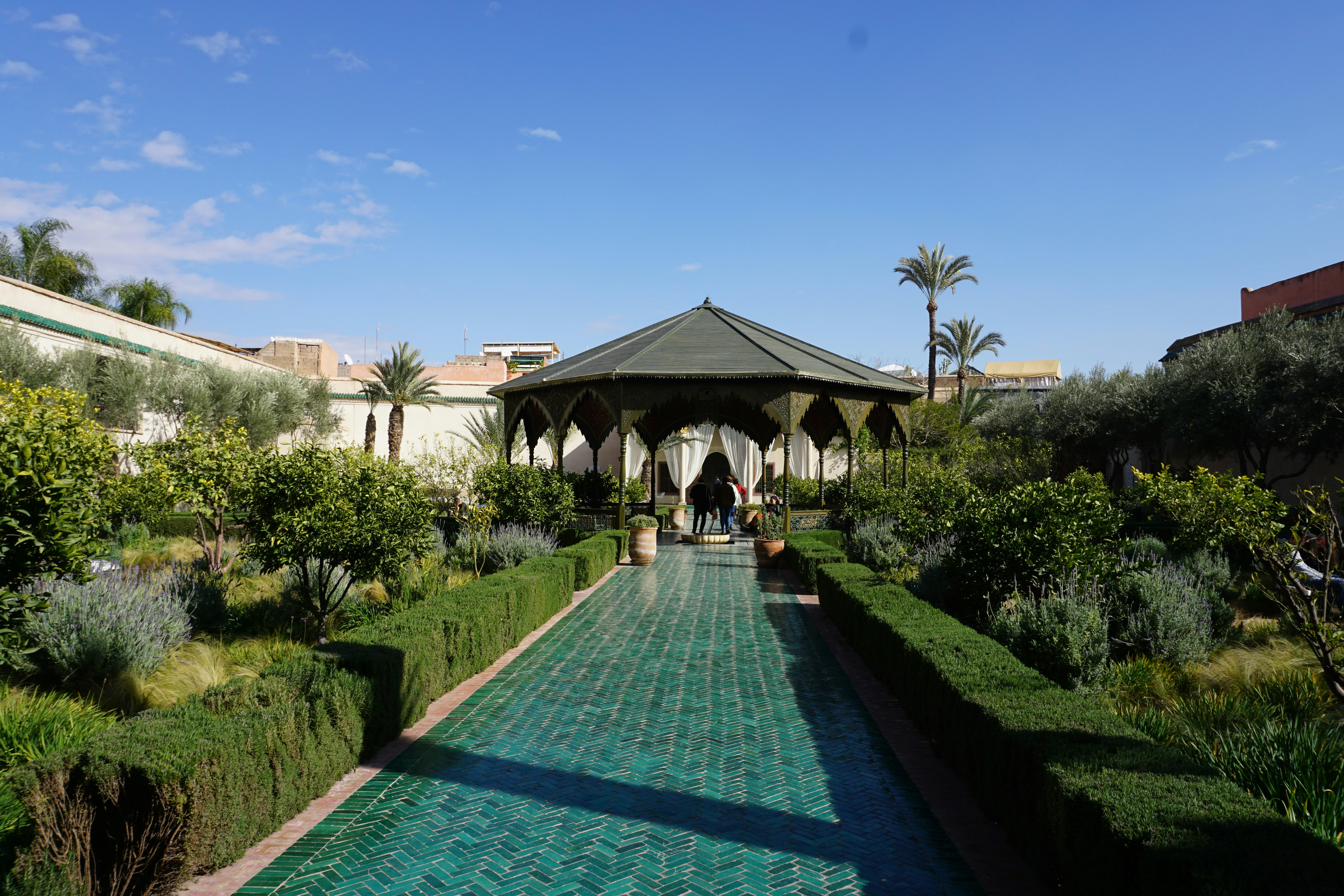people walking on pathway near white concrete building during daytime, 