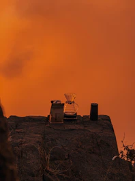 Close-up of hands preparing specialty coffee with a manual pour-over on a rocky summit.