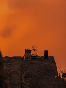 Close-up of hands preparing specialty coffee with a manual pour-over on a rocky summit.