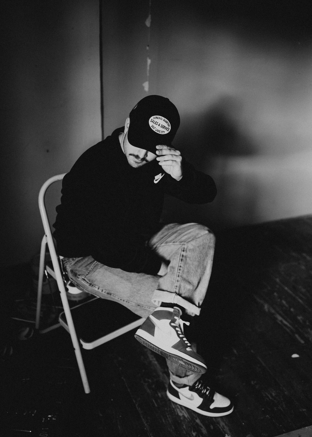 man in black sweater and gray denim jeans sitting on folding chair