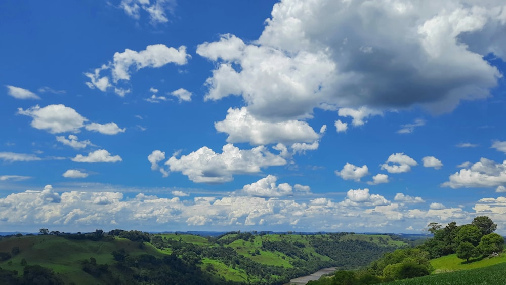 green mountains under blue sky and white clouds during daytime