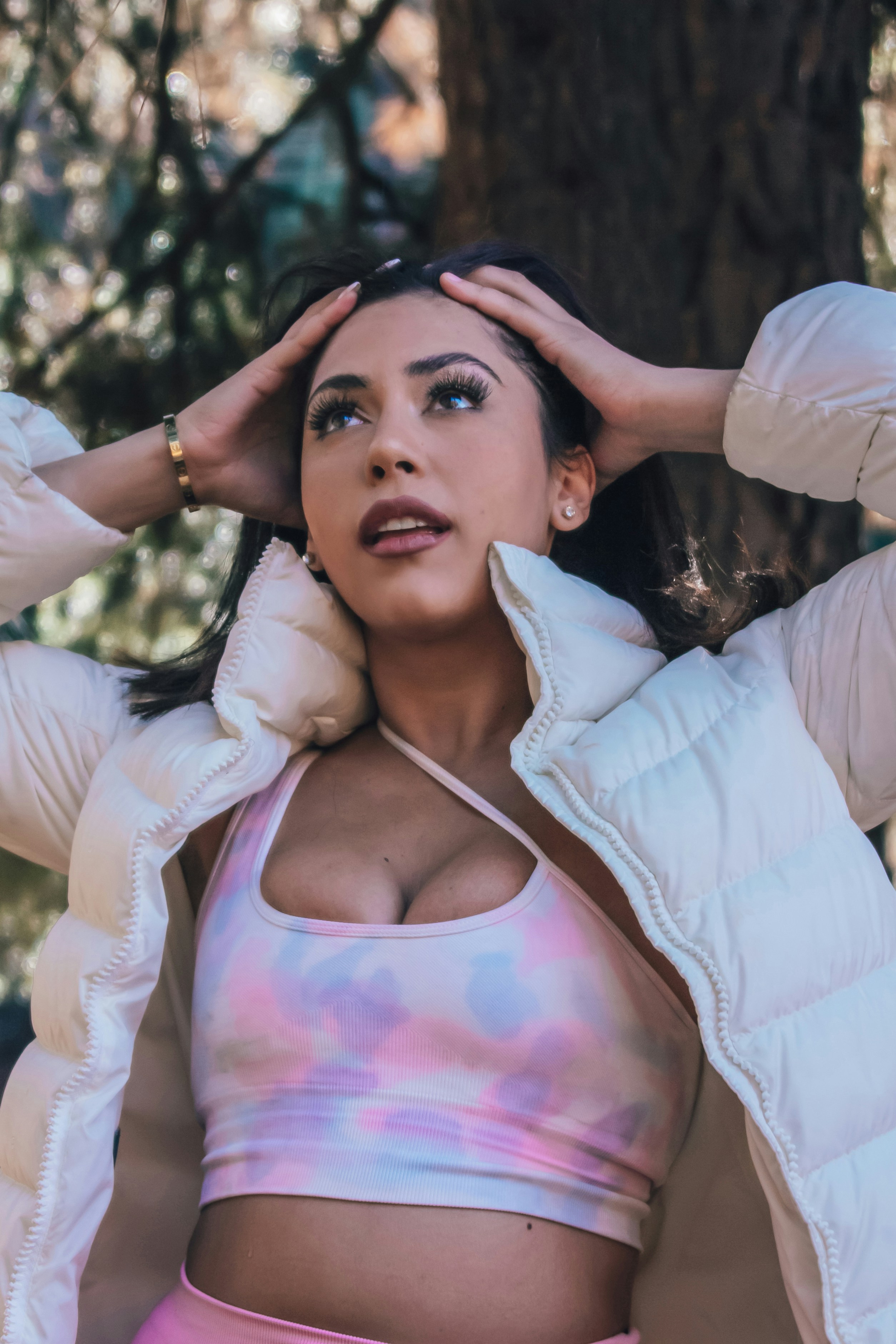 Frau in weißer Jacke tagsüber in der Nähe grüner Bäume