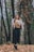 woman in black pants standing in forest