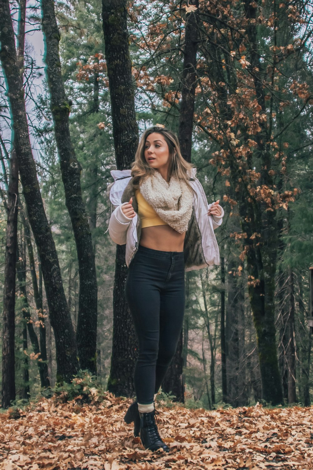 Mujer en pantalones negros de pie en el bosque