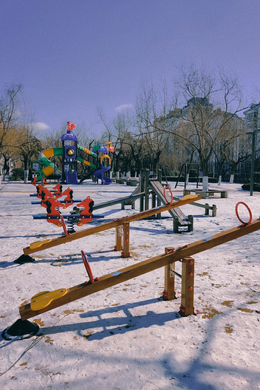 brown wooden bench on snow covered ground during daytime