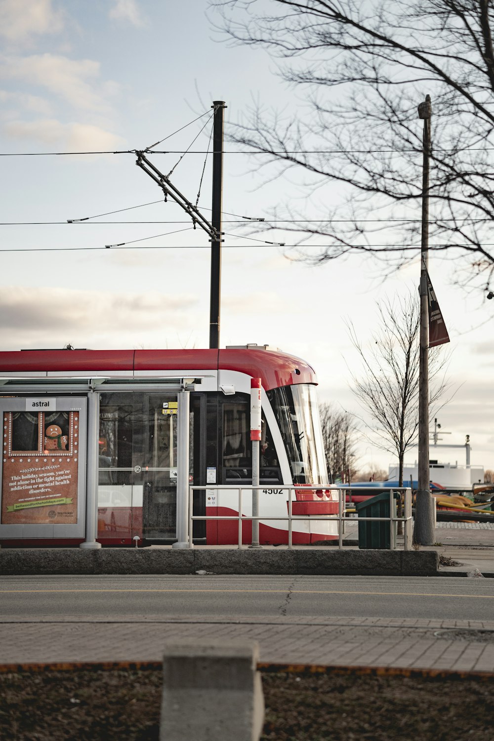 red and white train near bare trees during daytime