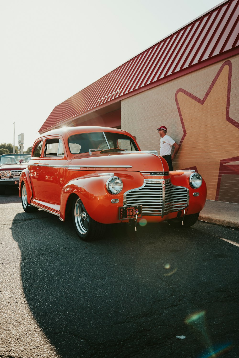 carro vintage vermelho estacionado perto do edifício vermelho