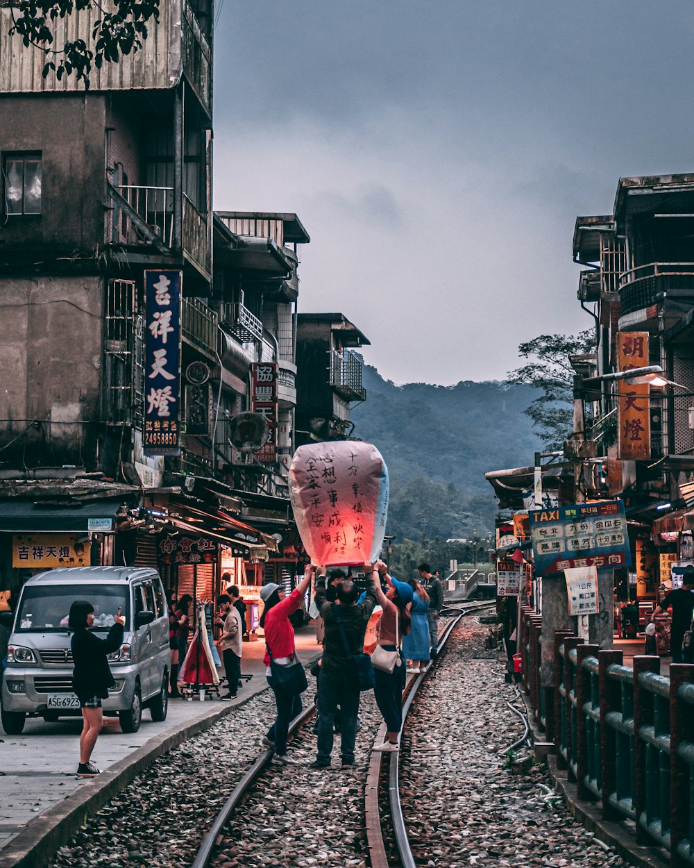 people walking on street with cars on road during daytime