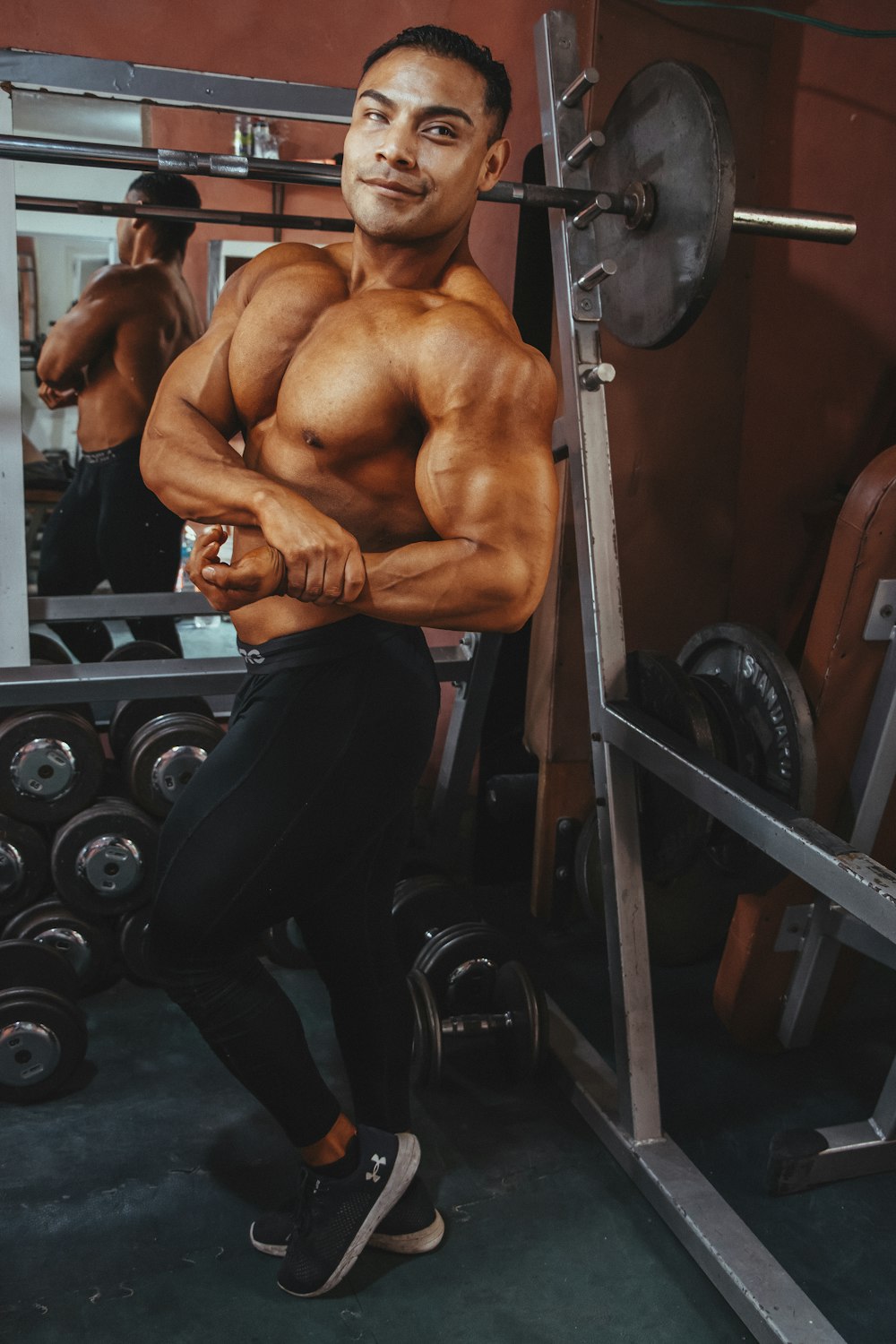 topless man in black pants sitting on black exercise equipment