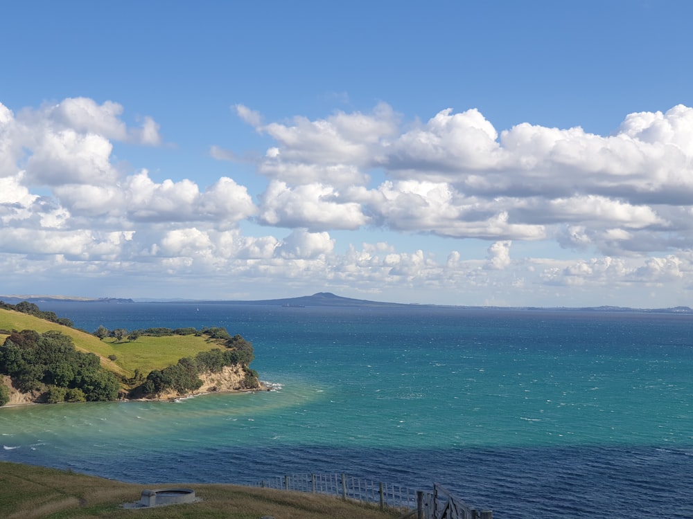 green island under blue sky and white clouds during daytime