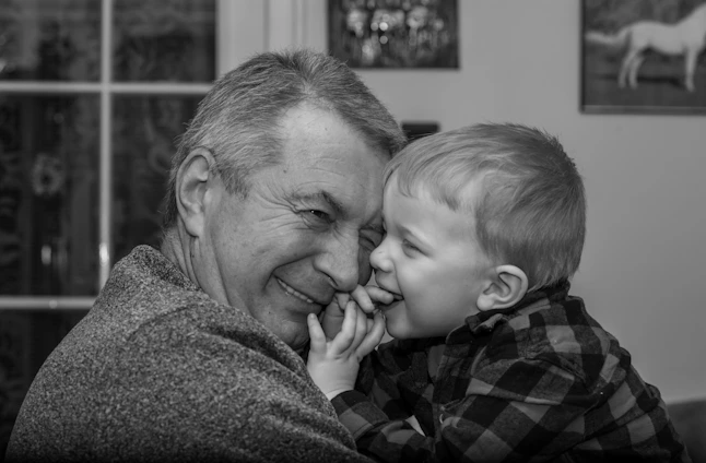 A warm, candid photo of a father and son sharing a quiet moment outside a neighborhood barbershop.