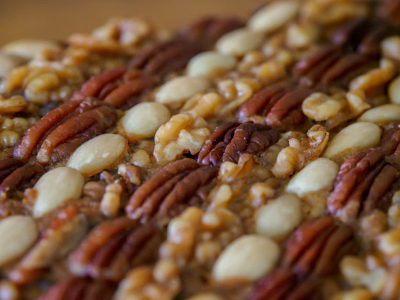 Close-up of premium natural nuts arranged elegantly on a rustic wooden table.