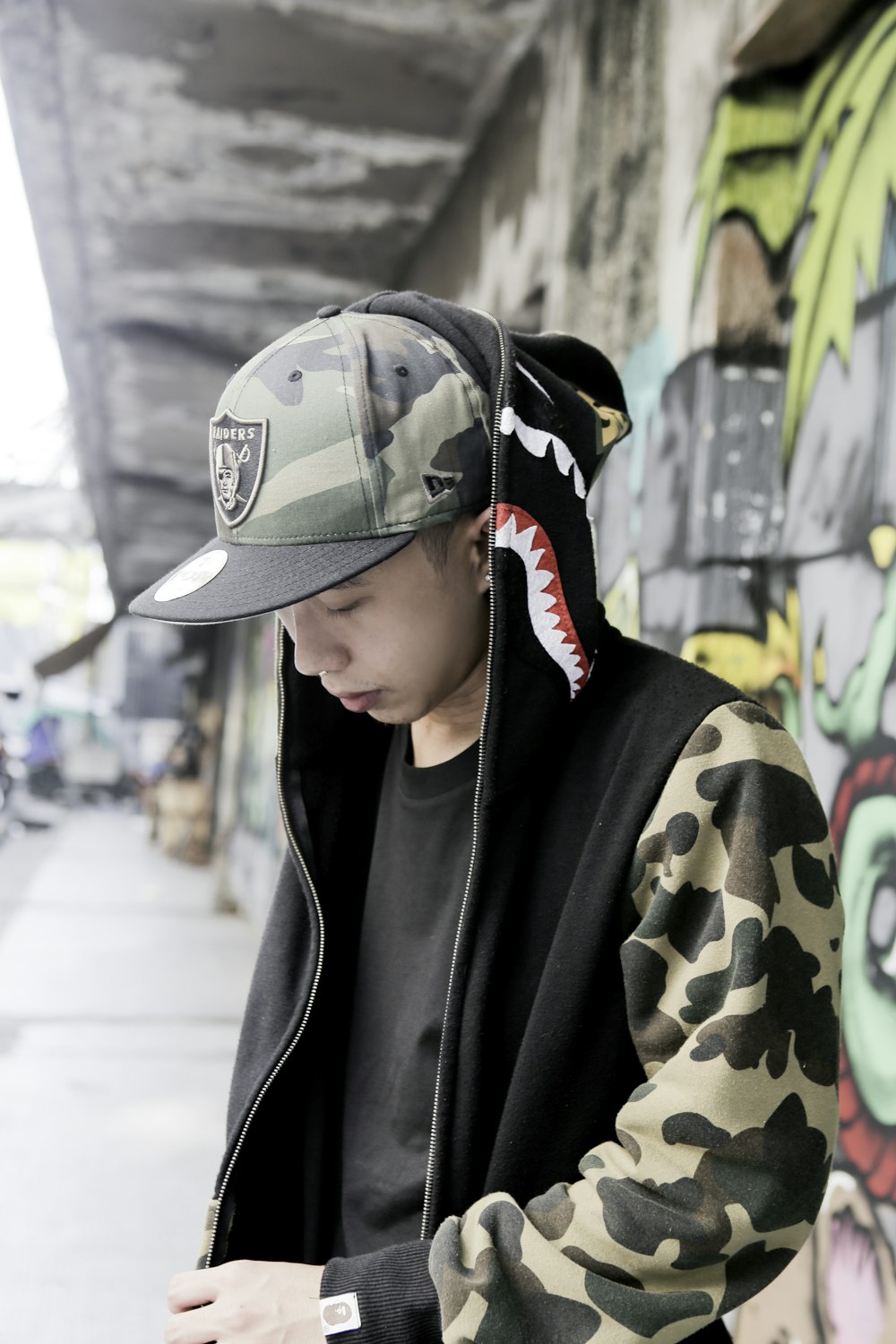 man in green and brown camouflage hat and black coat