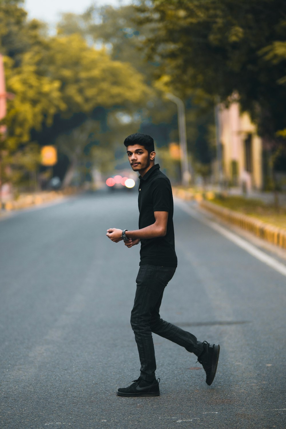 Foto Hombre con camisa negra y pantalón negro caminando por la carretera el – Imagen India gratis en Unsplash