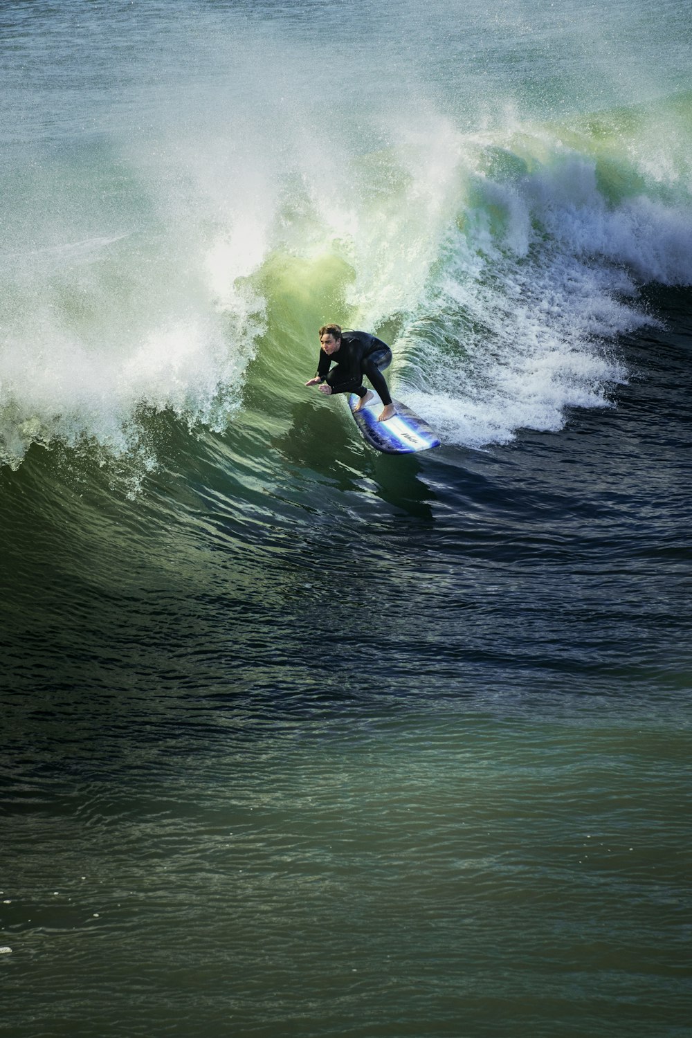 man surfing on sea waves during daytime