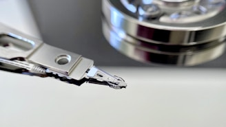 The image captures a close-up view of a hard drive's read/write head alongside a stack of platters. The metallic surfaces and intricate mechanical components are prominently displayed, showcasing the precision engineering of the device.