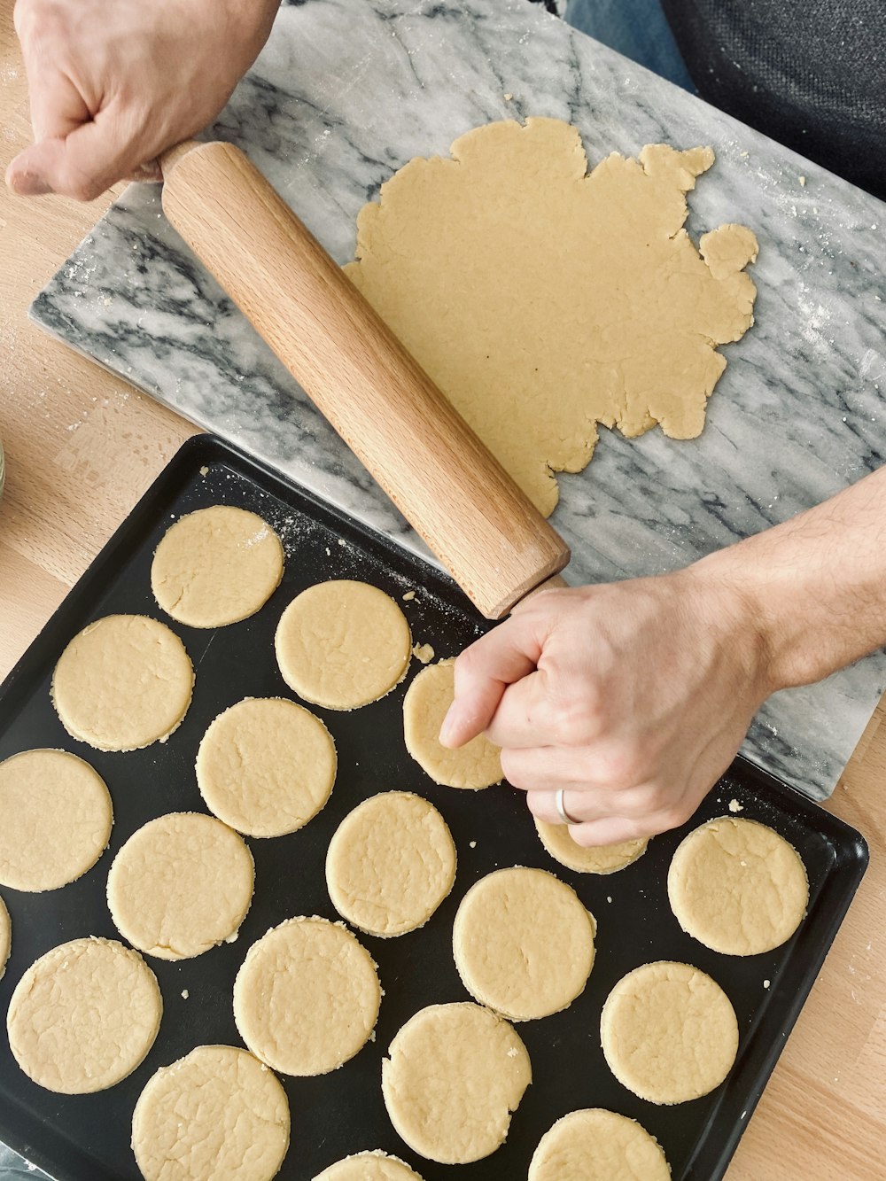 person holding brown wooden rolling pin