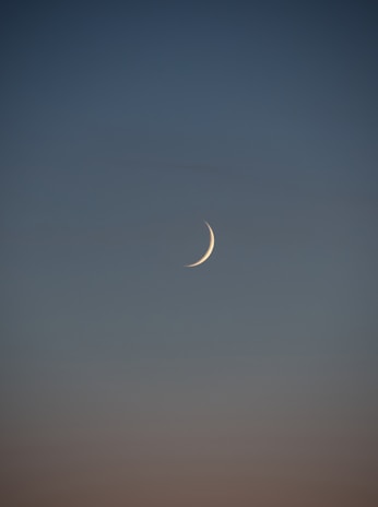 white crescent moon in the sky