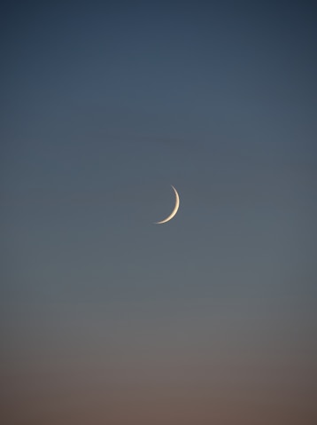 white crescent moon in the sky