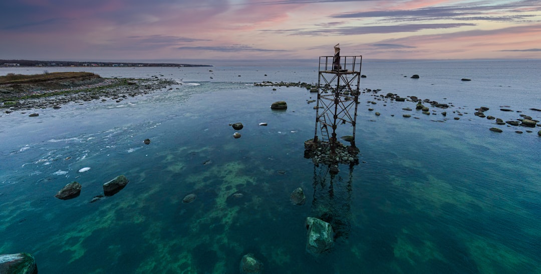 black and white tower on body of water during daytime