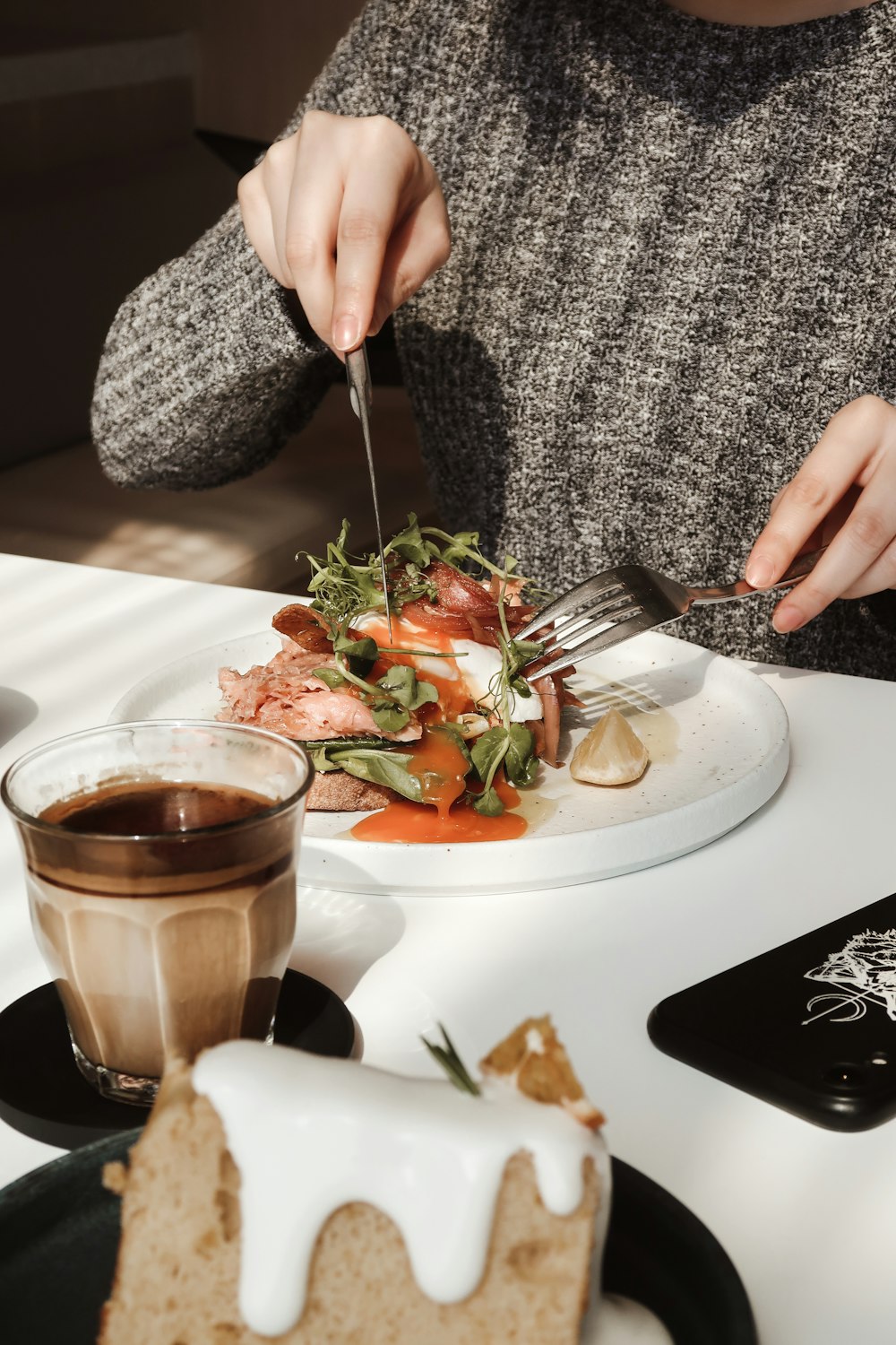 a woman is cutting into a plate of food