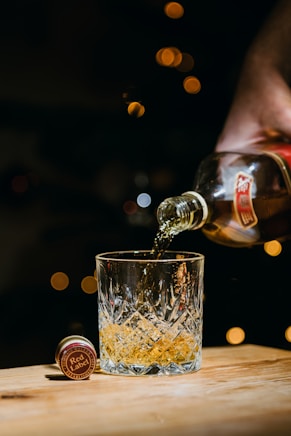 person pouring water on clear drinking glass