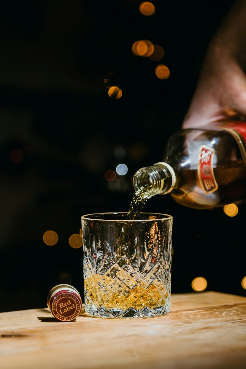 person pouring water on clear drinking glass