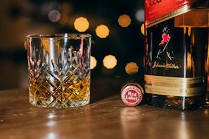 Bottles of Armenian cognac and whiskey glowing softly with a sleek gold-accented label design.