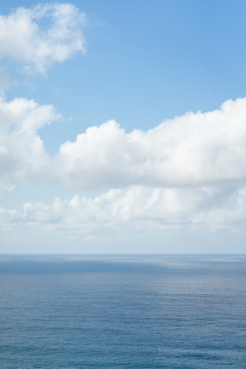 blue sea under white clouds during daytime