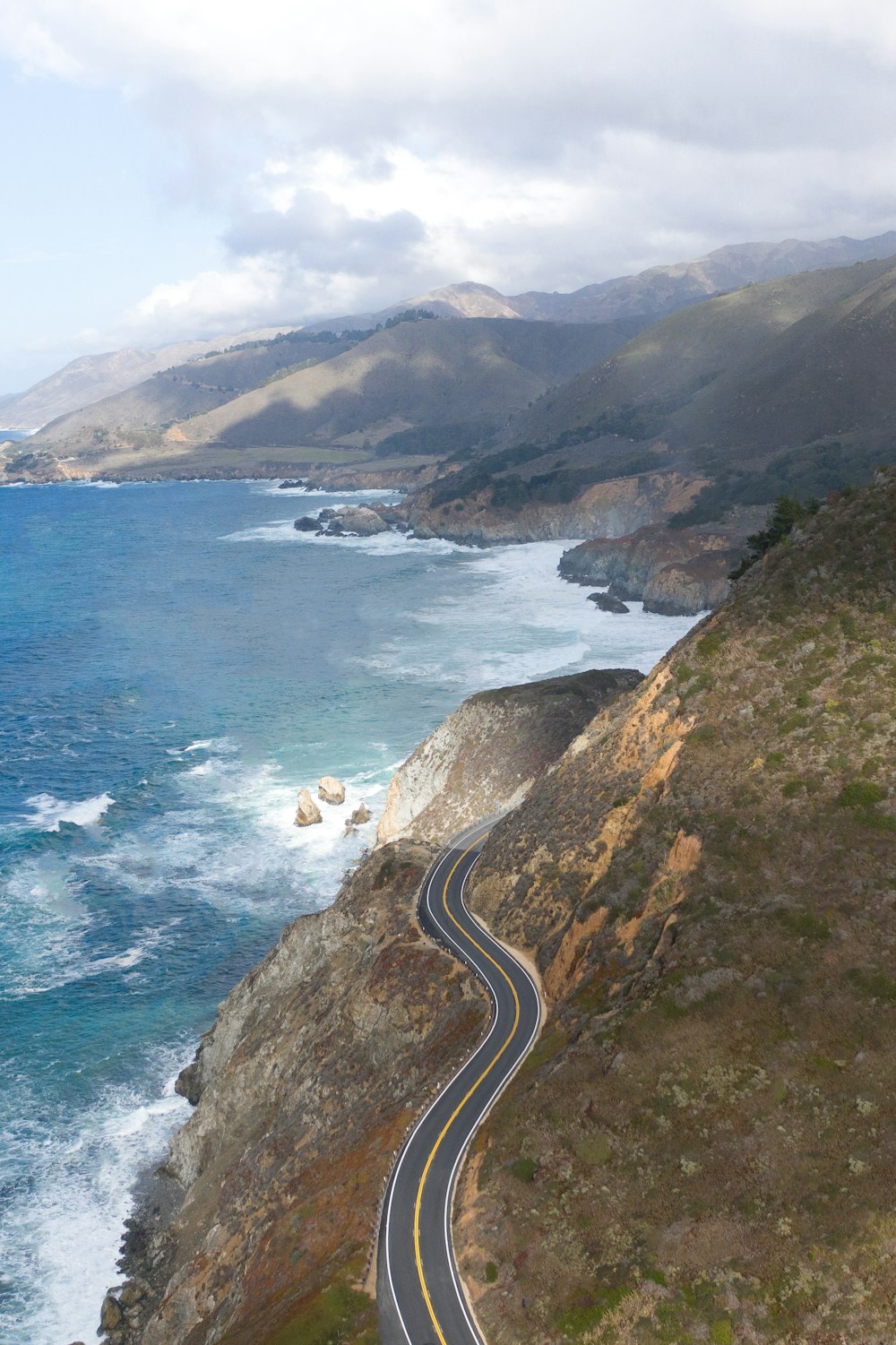 aerial view of a road in the middle of a mountain