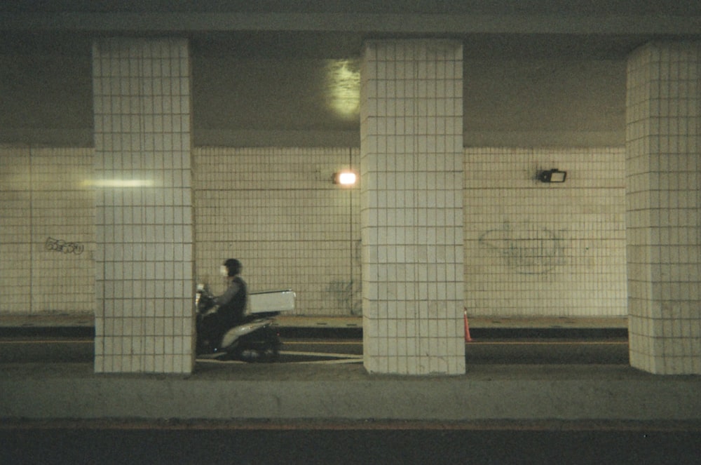 man in black jacket sitting on bench