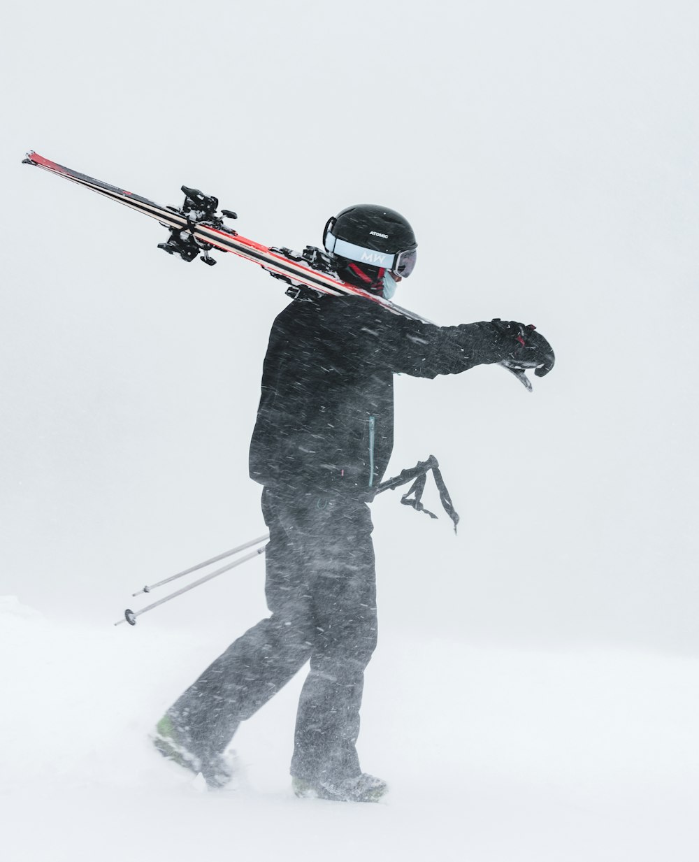 man in black jacket holding black and red rifle