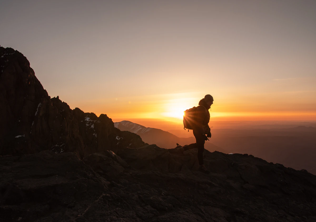 Silhouette of a hiker on a rocky ridge at sunset, High Atlas, Morocco