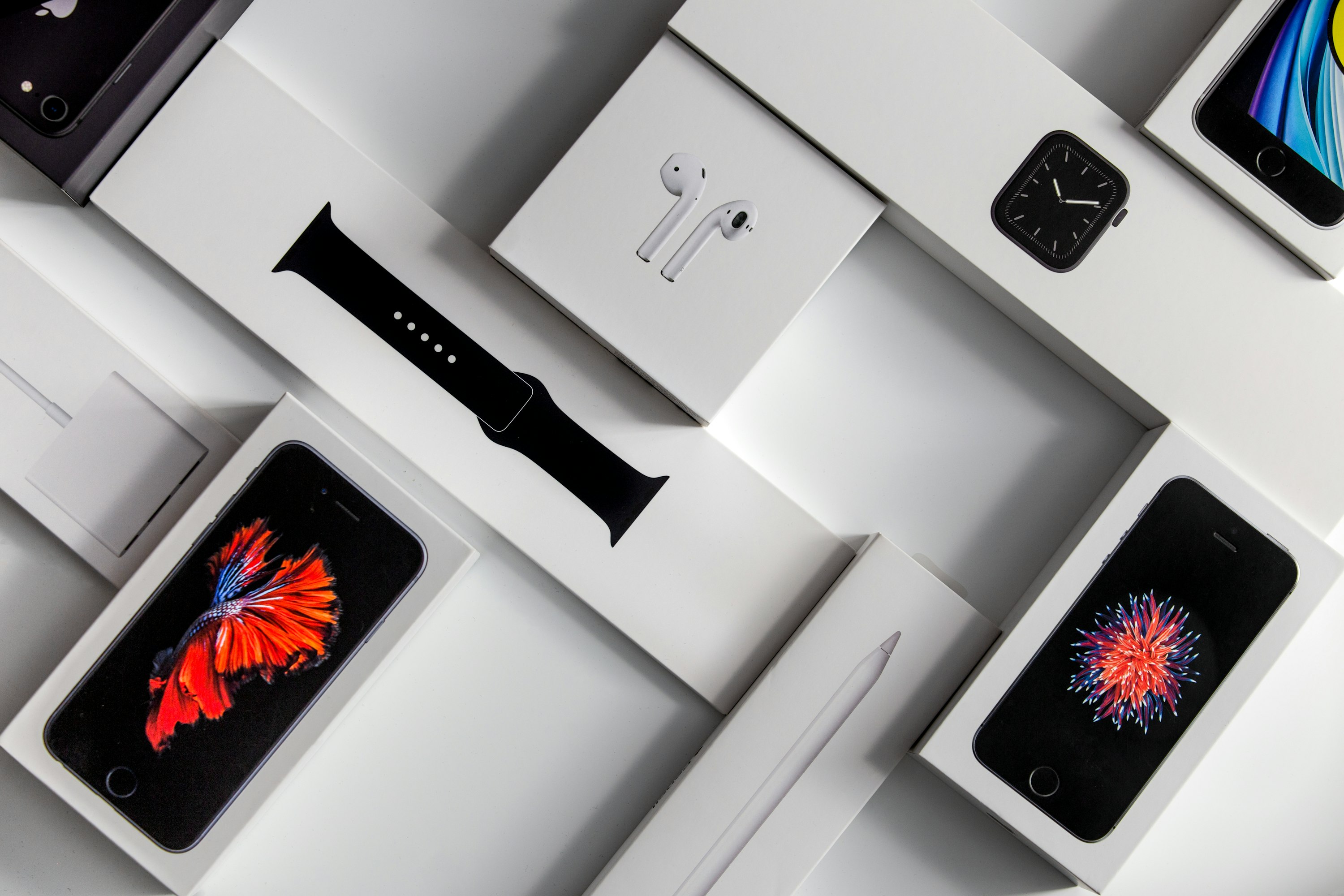 Várias caixas de produtos da Apple sobre uma superfície branca. 